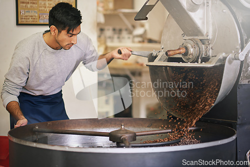 Image of Coffee shop, small business and man at machine for roasting with blending, production or quality control. Entrepreneur, barista or roaster with beans at cafe, sustainable startup and espresso process