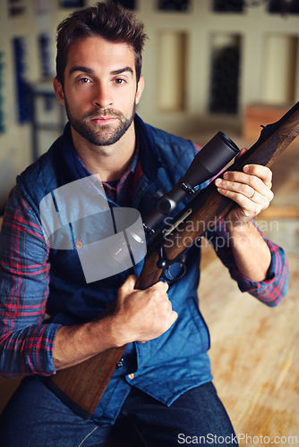 Image of Hunter, pride and portrait of man with gun for game shooting, adventure and hobby with confidence. Sports, trophy hunting and serious person in cabin with rifle, equipment and weapon gear in home