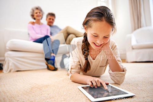 Image of Relax, kid or girl with tablet for elearning or studying for remote education on carpet at home. Family, grandfather or grandmother with a happy child reading ebook or streaming video or movie