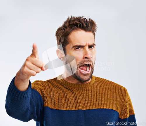 Image of Frustrated man, portrait and pointing to you with shout for choice, pick or rage on a white studio background. Angry male person or upset model yelling or screaming with mood or attitude on mockup