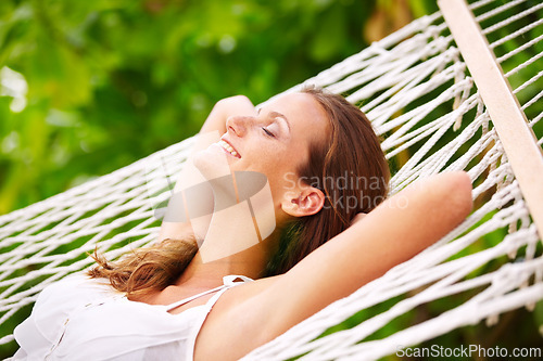 Image of Happy woman, rest and wellness on hammock in outdoor, peace and summer vacation in sunshine in nature. Young person, smile and sleep by trees at beach resort, calm and holiday for leisure on island