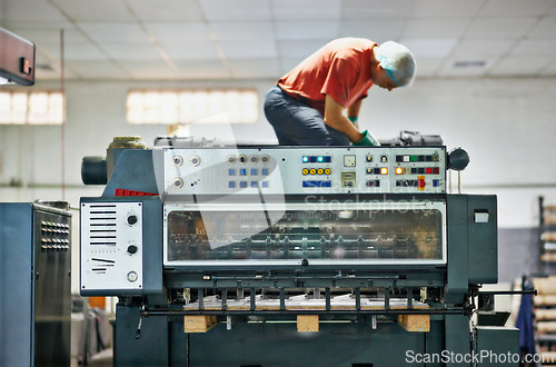 Image of Printing, man and machine in factory for maintenance with repair work, fixing problem and service with gloves. Technician, professional employee and machinery in distribution plant and manufacturing