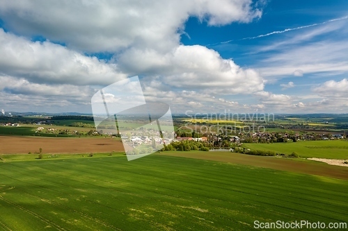 Image of Drone flies over countryside with green field.