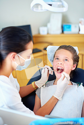 Image of Girl, child and woman at dentist for healthcare with dental tool, consultation and mouth inspection for oral health. Orthodontics, kid patient or gloves for teeth cleaning, gingivitis or medical care