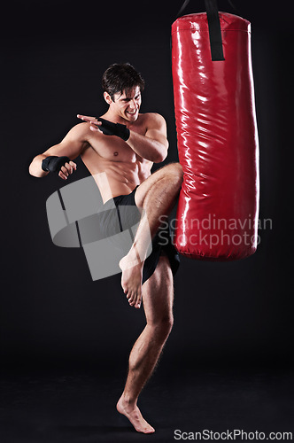 Image of Man, fighter and boxing bag with kick in studio for self defence workout, martial arts or black background. Male person, wellness and mockup space for strength training with gym, fitness or sport