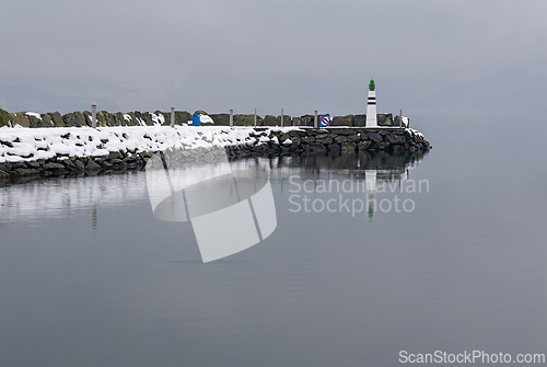 Image of A solitary lighthouse amidst winters embrace