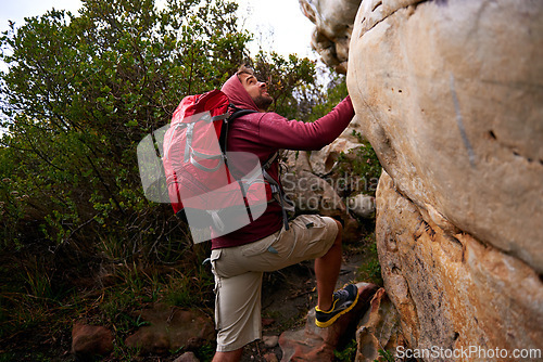 Image of Rock climbing, hiking and man on mountain, nature and environment for outdoor adventure. Male person, athlete or sport in environment for exercise, fitness or health with backpack by plants in forest