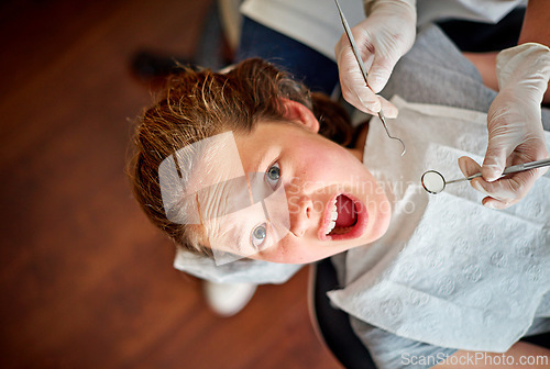 Image of Scared, kid and portrait at dentist for teeth, cleaning and fear of healthcare at clinic or hospital. Dental, care and child afraid of tools in mouth and scream for help in medical appointment