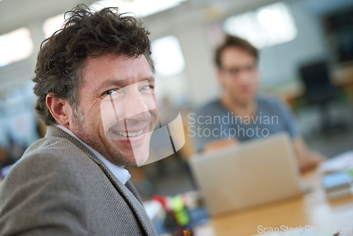 Image of Happy, portrait and creative man coworking in office with team and planning project with laptop on desk. Mature, employee and productivity in collaboration, cooperation or development of ideas