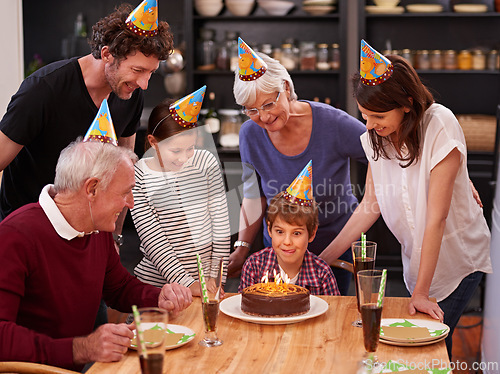 Image of Family, birthday cake and restaurant with boy, parents and grandparents together with fun and candles. Happy, smile and dessert with children and celebration with event food and party hats at a table