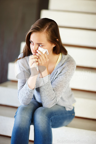 Image of Crying, stress or woman in house with tissue, depression or mental health, crisis or disaster. Stairs, overthinking or person with tears, anxiety or overwhelmed by fail, mistake or ptsd trauma memory