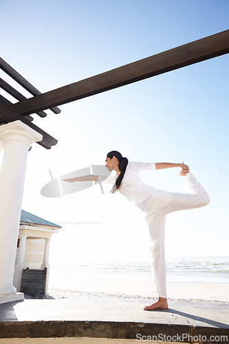 Image of Woman, yoga or dancer pose on beach in mindfulness, practice of meditation as health and fitness. Female yogi or natarajasana or leg to workout as spiritual, zen or wellness for balance and gratitude