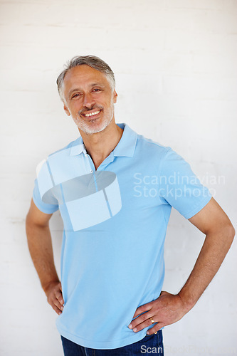 Image of Portrait, confidence and smile of senior man on brick wall for fashion isolated on a white background in Switzerland. Face, mature and happy person in casual clothes, shirt and positive for style