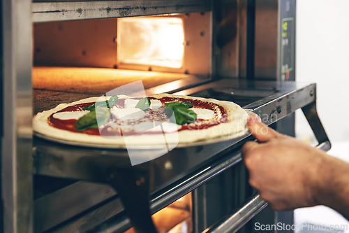 Image of Fresh pizza placed in oven