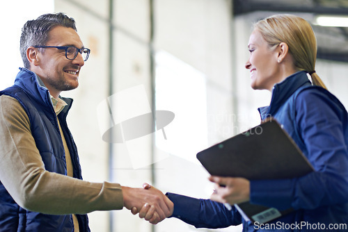 Image of Business people, handshake and welcome for partnership, collaboration and agreement. Professional, clipboard and shaking hands for introduction, b2b onboarding or teamwork in shipping warehouse