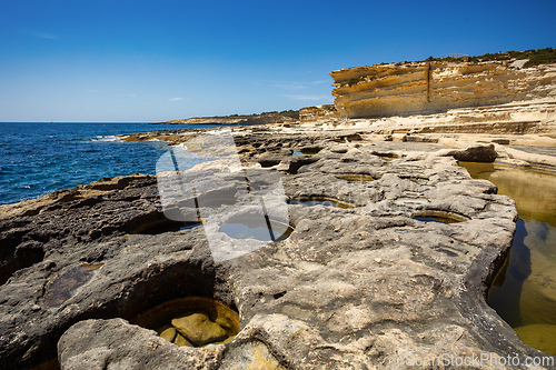 Image of Crystal clear turquoise water in blue lagoon. St. Peters pool - rocky beach at Malta