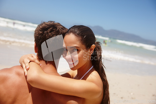 Image of Couple, beach and hug on sand with travel for bonding, summer vacation and portrait with blue sky. Man, woman and embrace by ocean for holiday adventure, romantic getaway and swimwear in California