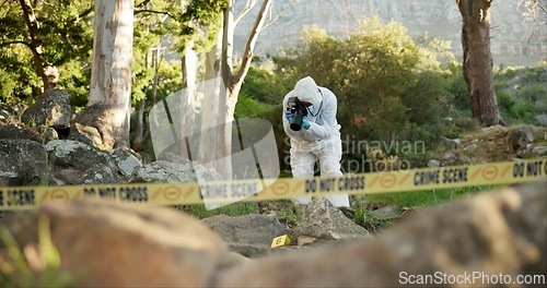 Image of Forensic, photographer and evidence at crime scene for investigation in forest with police tape and safety hazmat..Csi quarantine, expert investigator and pictures for observation and case research