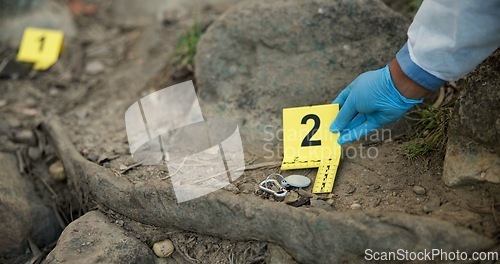 Image of Hands, evidence marker and csi for investigation at crime scene with keys in ground or hazmat for safety in forest. Location quarantine, expert investigator or case research with observation in woods