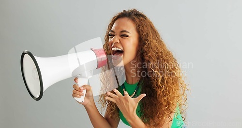 Image of Happy woman, shouting and pointing with megaphone for motivation on a gray studio background. Excited female person screaming with bullhorn in winning, celebration or announcement for choice or pick
