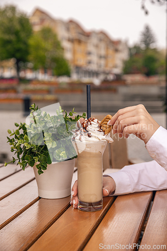 Image of Woman enjoying a glass with iced coffee