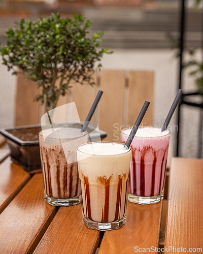 Image of Three milkshakes with chocolate sauce 