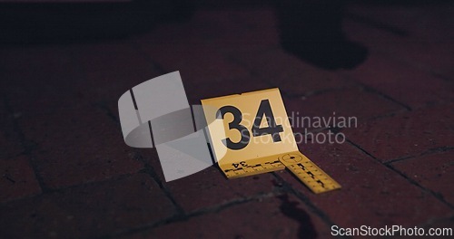 Image of Crime scene, investigation and blood on floor for evidence, forensics and dna for pathology research. Marker, security and yellow sign with number for warning, caution and incident on red bricks