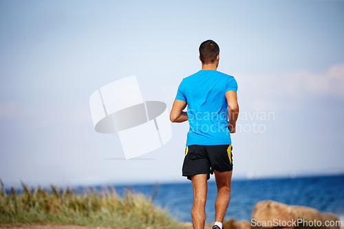 Image of Male athlete, outdoor and running for fitness, health and wellness in nature for workout or exercise. Sporty man, training and cardio with endurance, muscles and strength for healthy living or gym