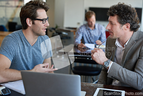 Image of Copywriter, employees and men brainstorming, laptop and tablet on desk, office and teamwork in company. Planning, colleagues and male coworkers with technology for project, working and business