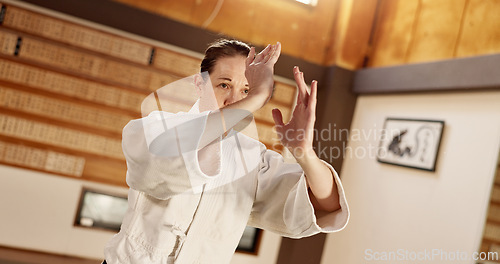 Image of Aikido class, woman and fight for martial arts, strike or together for combat at training, gym or dojo. Japanese person, student and hands for exercise, workout or fitness with zen, conflict or club