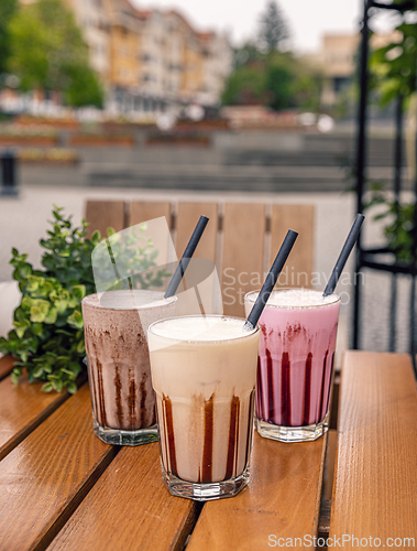 Image of Three milkshakes with chocolate sauce