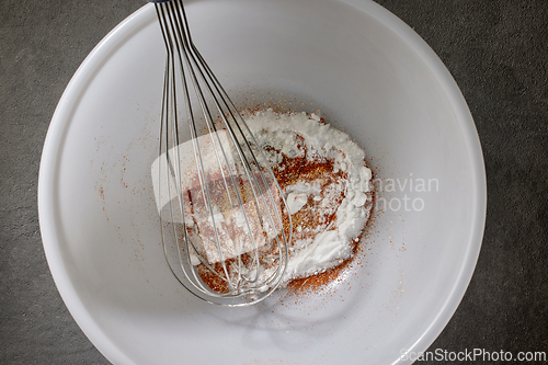 Image of spices with salt and baking powder are mixed in a white bowl 
