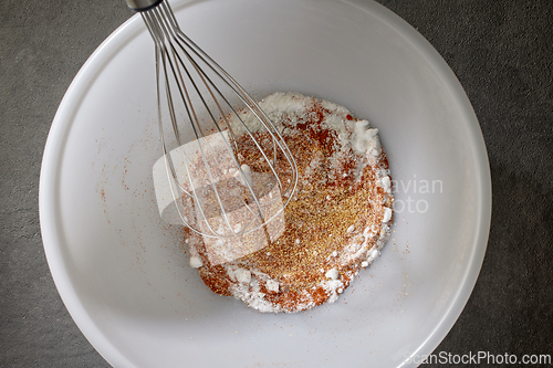 Image of spices with salt and baking powder are mixed in a white bowl 
