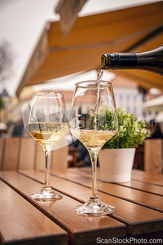 Image of Glass is being filled with white wine