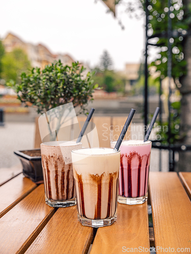Image of Three milkshakes with chocolate sauce