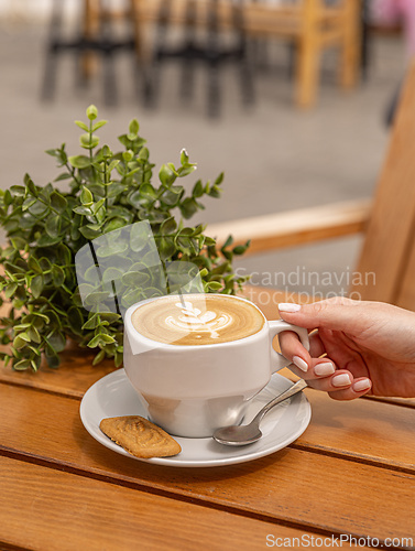 Image of Woman holding latte art coffee