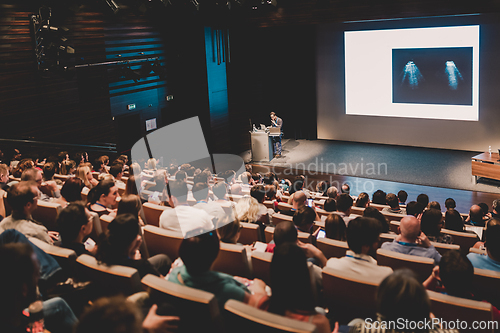 Image of Business speaker giving a talk in conference hall.