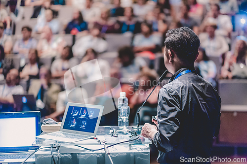 Image of Public speaker giving talk at Business Event.