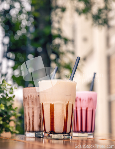 Image of Three milkshakes with chocolate sauce