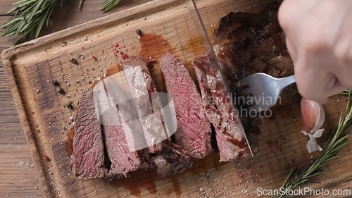 Image of Chef slicing freshly grilled juicy beef steak 