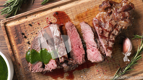 Image of freshly grilled sliced steak with green parsley sauce