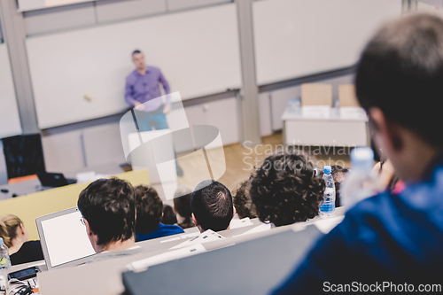 Image of Professor giving presentation in lecture hall at university.