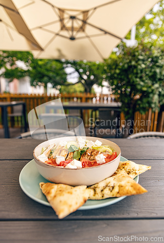 Image of Greek salad with chicken, feta cheese and pita bread