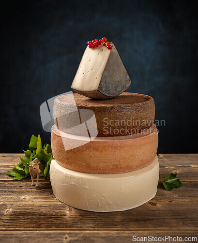 Image of Wedge of cheese is balancing on top of another cheese
