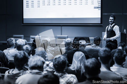 Image of Speaker Giving a Talk at Business Meeting. Audience in the conference hall. Business and Entrepreneurship concept. Black and white blue toned image