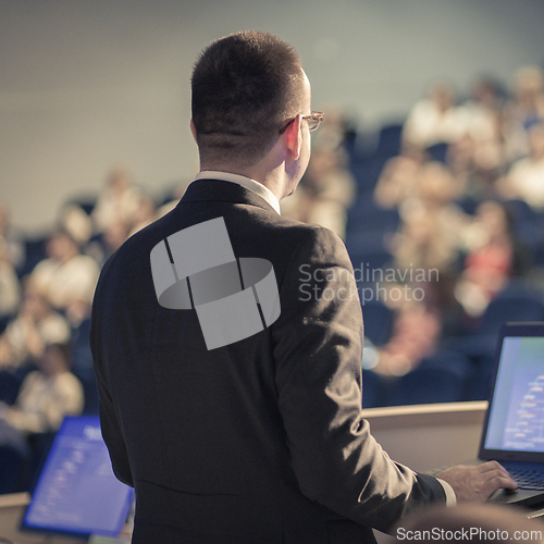Image of Public speaker giving talk at business event.