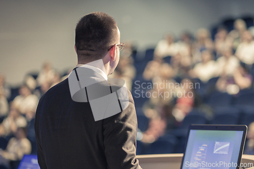 Image of Public speaker giving talk at business event.