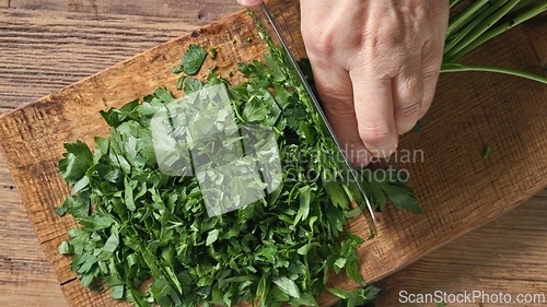Image of Chef chops fresh green parsley