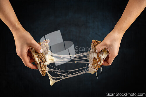 Image of Two hands pulling apart a grilled cheese