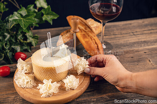 Image of Woman hand taking slice of cheese